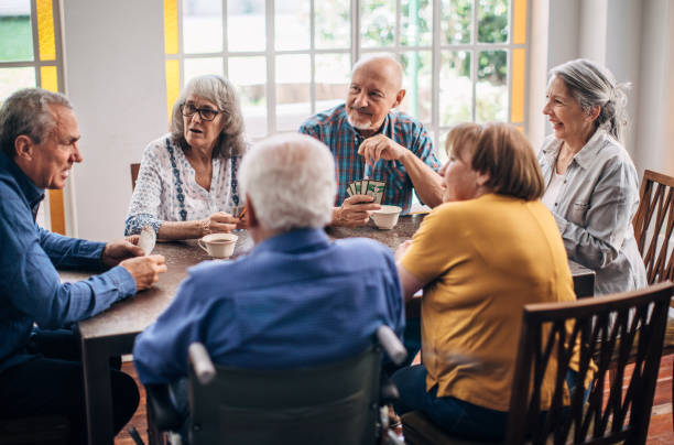 istock Senior friends having fun playing cards 1199178240