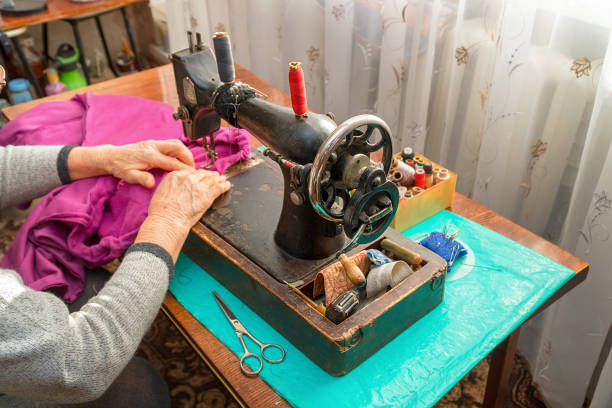 istock Woman sews on an old sewing machine 1199178277