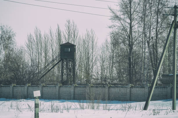 Watchtower at the fence with barbed wire. Soft focus