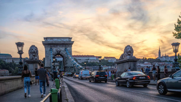 ブダペストの歴史的なセチェニチェーンブリッジとウォーキング観光客 - chain bridge budapest bridge lion ストックフォトと画像