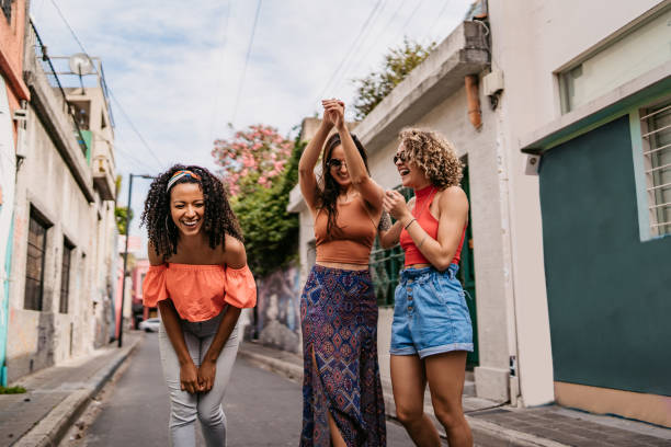 istock Three young women walking and laughing 1199180853