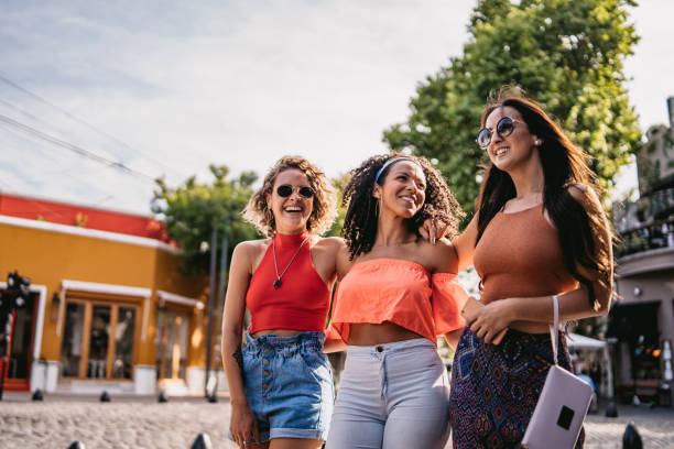istock Three young women walking and laughing 1199180875