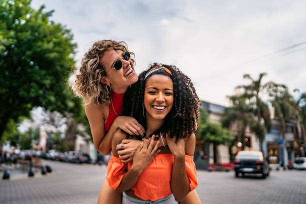 Two beautiful women having fun Two young beautiful smiling Argentinian women having fun at city street, having a piggyback ride. Shooting Buenos Aires, Argentina. girlfriend stock pictures, royalty-free photos & images