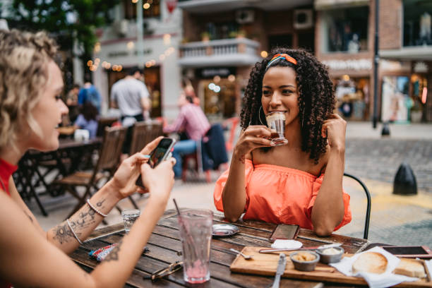 istock Two young women at sidewalk cafe 1199180958