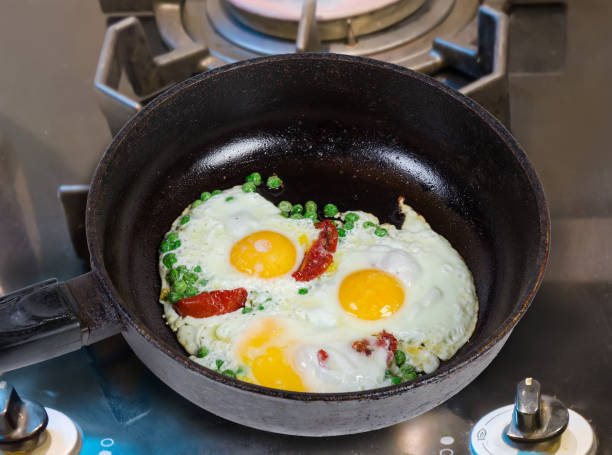 istock Eggs fried with green pea in frying pan on stove 1199180966