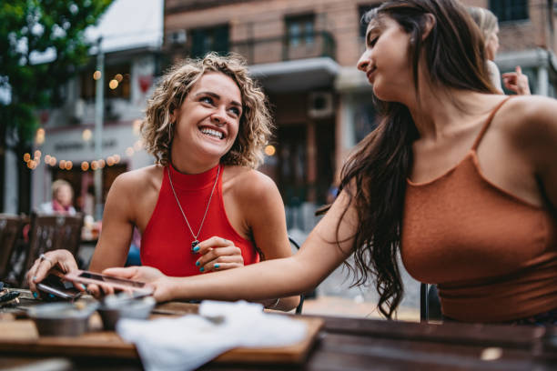 istock Two young women at sidewalk cafe 1199180968