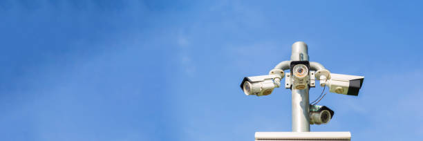 istock Modern 3 way security CCTV surveillance camera against blue sky background with copy space 1199181016