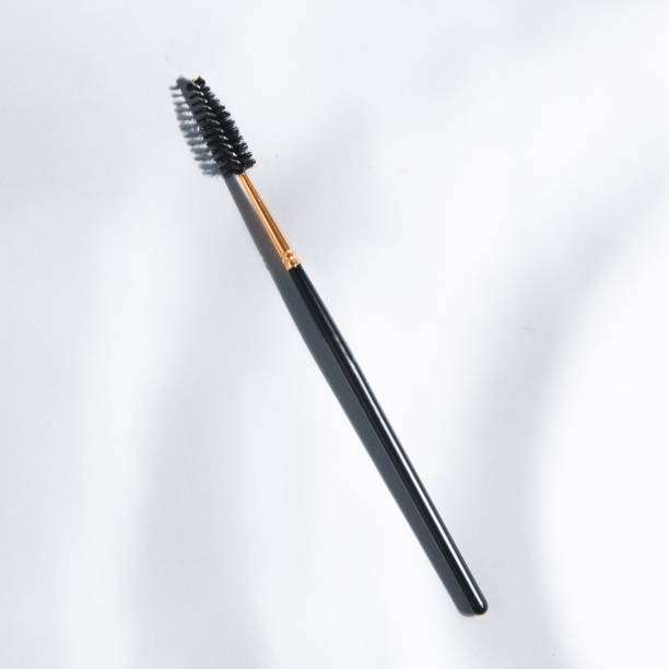 istock Makeup brush. Black plastic eyebrow brush. Light background with highlights for the site. A tool for a makeup artist. 1199181341