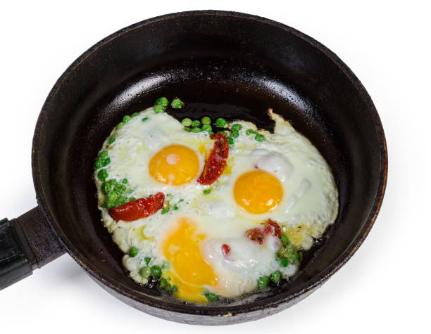 istock Eggs fried with green pea and tomatoes in frying pan 1199182275