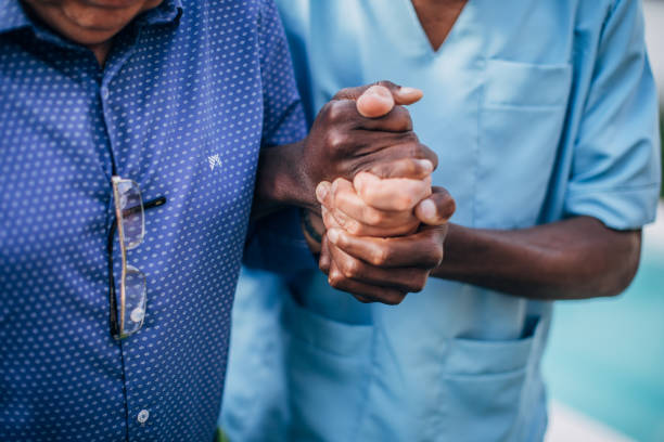 istock Man nurse assisting senior man in walking 1199182471