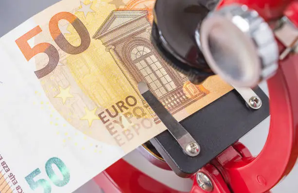 50 Euro under the microscope, testing counterfeit money. Anti-counterfeit technology. Concept image, selective focus