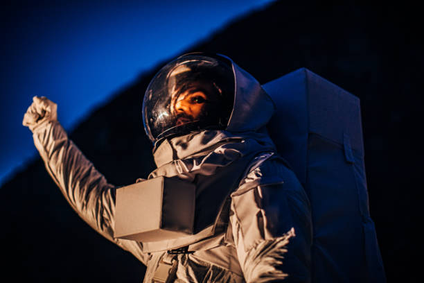 istock Astronaut with raised fist standing alone on dark planet 1199184448