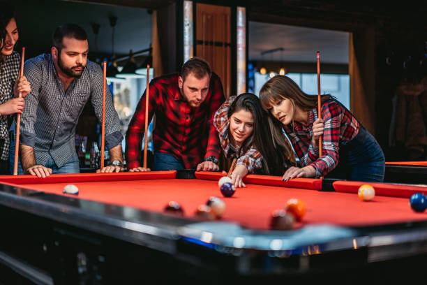 Young Caucasian beautiful friends playing snooker together.
