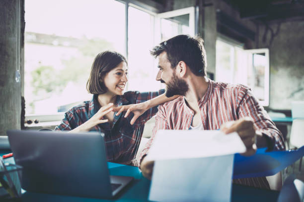istock Happy design professionals talking about business reports at casual office. 1199194091