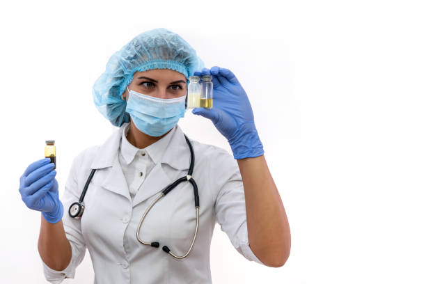 woman in protective uniform holding different ampoules isolated on white - surgical glove human hand holding capsule imagens e fotografias de stock