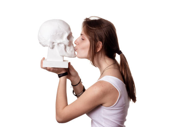 istock Female kissing a gypsum human skull. isolate 1199200431