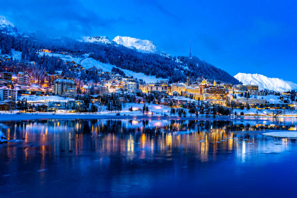 vista das belas luzes noturnas da cidade de st. moritz, na suíça, à noite no inverno, com reflexão do lago e montanhas de neve em backgrouind - mountain night switzerland engadine - fotografias e filmes do acervo