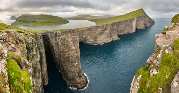 Dramatic atlantic rocky coastline cliffs landscape in Vagar. Faroe Dramatic atlantic rocky coastline cliffs landscape in Vagar. Faroe islands vágar photos stock pictures, royalty-free photos & images