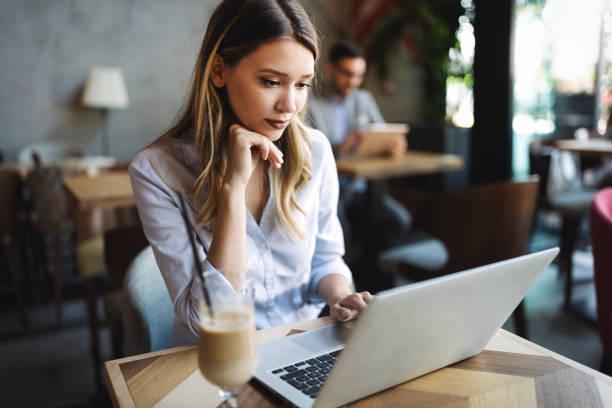 istock Beautiful business woman using notebook in cafe 1199203234