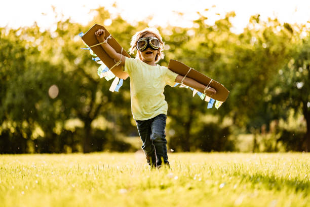 istock Small boy running with wings at the field 1199203242