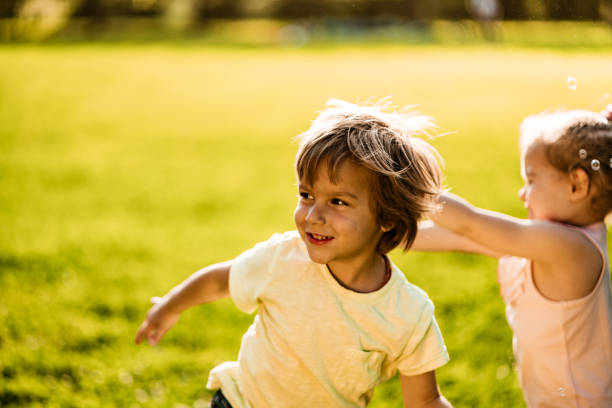 istock Kids playing in nature with soap bubble 1199207490