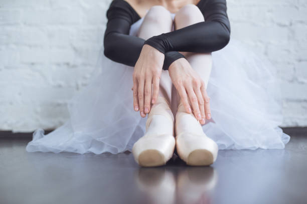 istock Young ballet dancer sitting leaning white wall in studio active lifestyle 1199208130