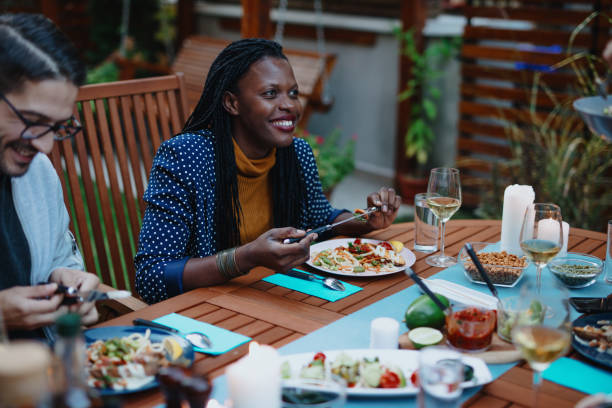 istock Dinner party guests talking at the table and eating 1199209612
