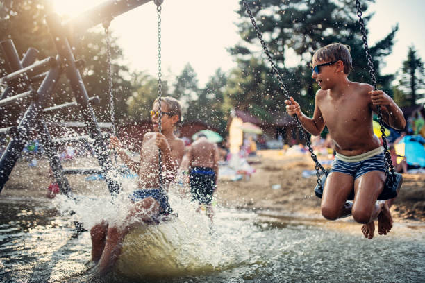 istock Two little boys playing on lake swing 1199210860