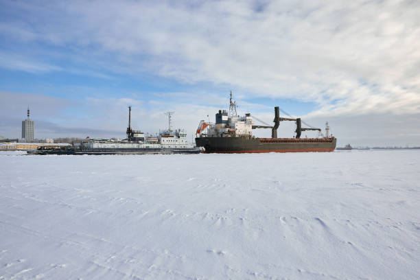 istock cargo ship pushes tug in the ice 1199211156