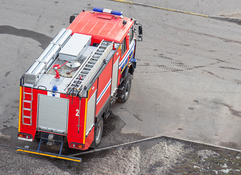 Red fire truck with emergency lights, saving people, threat to life, background