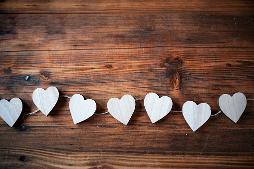 Little hearts on wooden background.