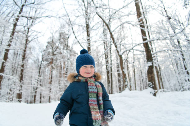 istock Happy child walking through winter forest 1199213565