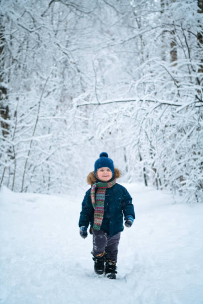 istock Happy child walking through winter forest 1199213567