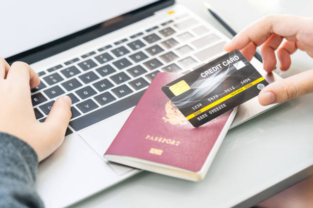 istock Female hands  typing on laptop computer with passport and credit card 1199215401