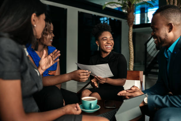 tutte riunioni d'affari occasionali africane. candid vero momento felice tra quattro colleghi di lavoro. - african descent foto e immagini stock