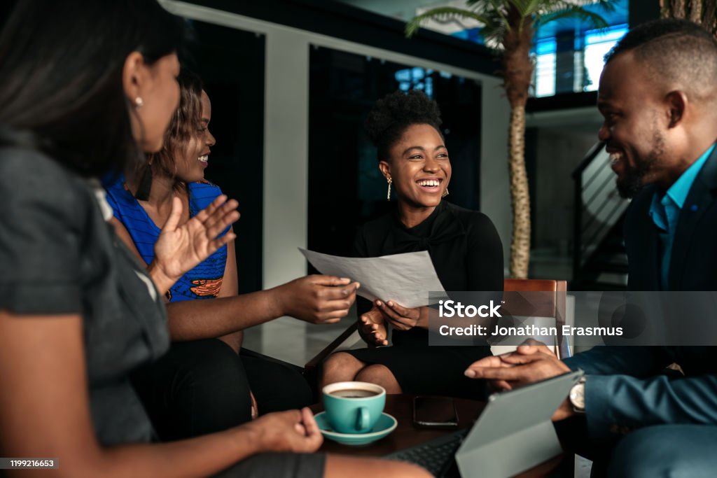 All african casual business meeting. Candid real happy moment between four work colleagues. African Ethnicity Stock Photo