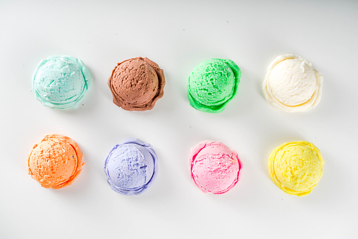 Colorful pastel ice cream with waffle cones, white background, copy space top view