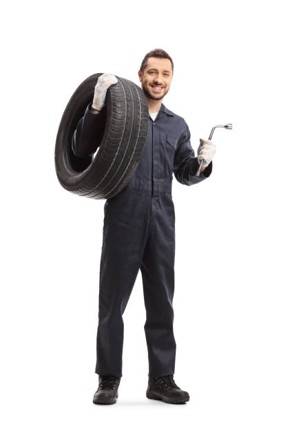 istock Auto mechanic holding a tire and a wrench 1199218251