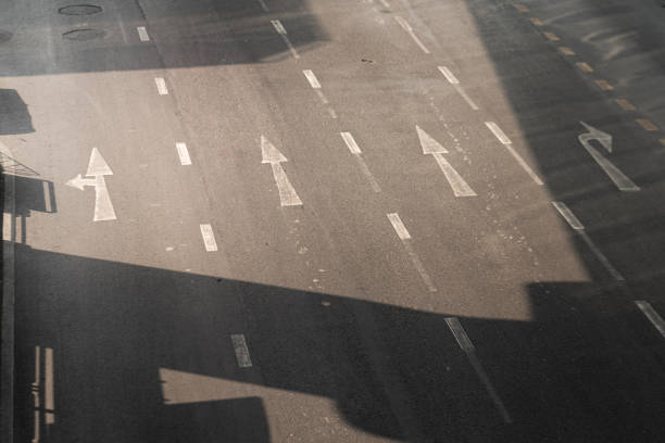 An empty 4 lanes asphalt road in downtown area of Bangkok during the day time. Selective focus photo at center area of the road.