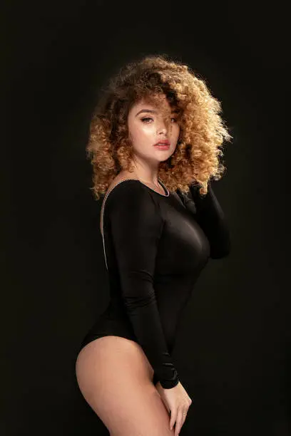 Photo of Elegant woman with curly hair posing.