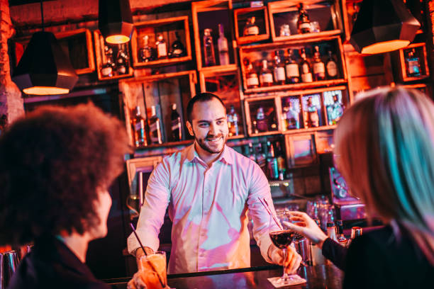 istock Two diverse female friends drinking together in a bar 1199229171