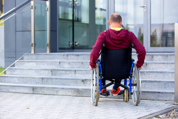 man on wheelchair and steps stock photo