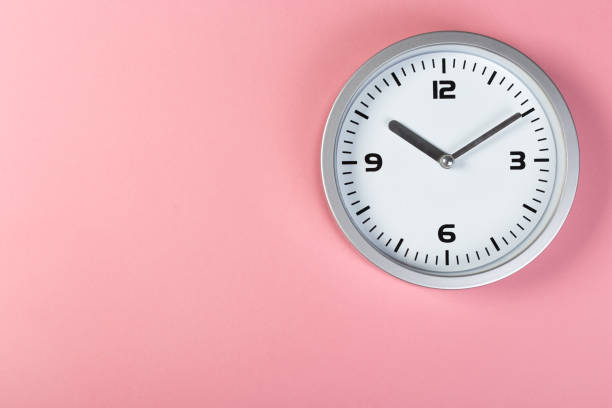 istock minimalistic white wall clock with light metal on a pink background. time concept. 1199231038