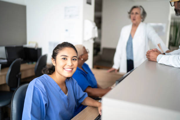 portrait of secretary working at hospital reception - medical assistant imagens e fotografias de stock