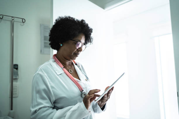 istock Mature female doctor using digital tablet at medical office 1199231606