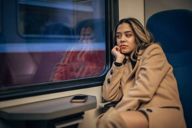 istock Woman sitting in train and looking through the window 1199231939