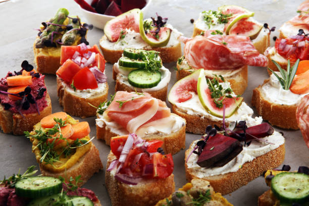istock Assorted bruschetta with various toppings. Appetizing bruschetta or brie crostini. Variety of small sandwiches. Mix bruschetta on table 1199232655
