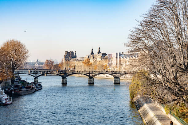 2019 The River Seine in Paris with the Passerelle des Arts bridge and the Louvre Museum buildings. Paris, France.