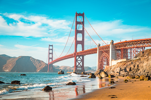 Classic view of famous Golden Gate Bridge in beautiful golden evening light on a sunny day with blue sky and clouds in summer, San Francisco, California, USA