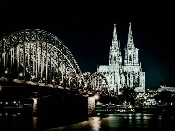 Kölner Dom - Cologne Cathedral Panorama with Hohenzollernbridge and river Rhein at night in black and white
